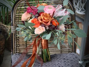 Bruidsboeket met verschillende bloemen op maat gemaakt voor de bruid in de kleuren oranje, groen en roze