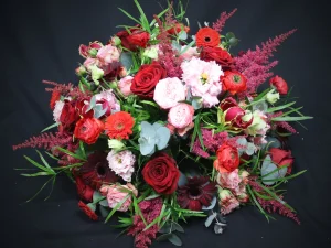 Rouw bloemstuk Contrast flowers. Een bloemstuk in een ronde vorm, met rode, witte en roze bloemen. Gemaakt door Bloeibloemen.nl