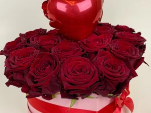Flowerbox Liefdes hart klein. Een roze box met daarin allemaal rode rozen gestoken in een blok oase. In het midden zit een kleine ballon in de vorm van een hart.