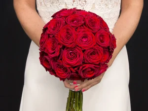 Een close up foto van een mooi rond bruidsboeket met rode rozen.