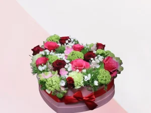 Bloemen hart met kleuren dit bloemen hart met de mooiste kleuren bloemen, daar wordt iedereen blij van.. Een box met verschillende witte, roze en zachtroze bloemen en rode rozen, gestoken in een stuk oase. Mooi voor de liefde of bijvoorbeeld Valentijnsdag.