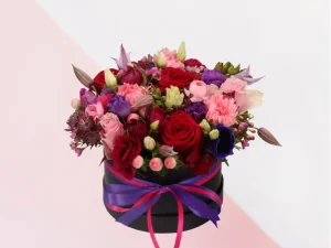 Flower Box Funky, een box met verschillende bloemen in de kleuren roze, paars en wit en rode rozen gestoken in een blok oase. Deze rozen zitten in een zwarte box.