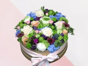 Flower box groot, een ronde box met verschillende soorten bloemen erin in de kleuren wit, zalmroze, blauw en paars.