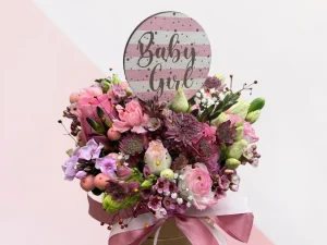 Flowerbox Baby Box Girl. Een roze box met daarin allemaal verschillende soorten bloemen gestoken in de kleuren roze, paars en wit. Speciaal voor de geboorte van een meisje.