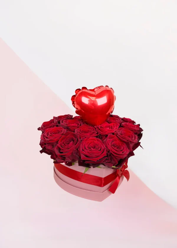 Flowerbox rozen hart klein. Een roze box met daarin allemaal rode rozen gestoken in een blok oase. In het midden zit een kleine ballon in de vorm van een hart. Bloemen voor Valentijnsdag