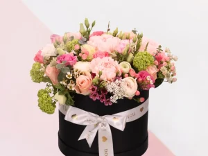 Flower box I love you, een box met verschillende bloemen gestoken in een blok oase. De kleuren van de bloemen zijn roze, lichtroze en zalmroze. Deze flowerbox is ook leuk voor bijvoorbeeld moederdag