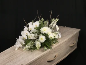 Orchidee white, een rouw bloemstuk op een kist met witte bloemen en een orchidee, gemaakt door Bloeibloemen.nl