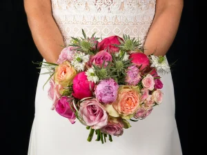 A round of roses, een bruidsboeket met verschillende kleuren roze in donkerroze, lichtroze en zalmroze.