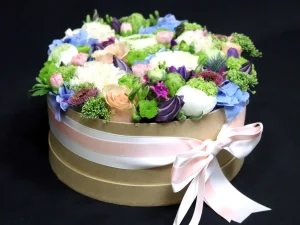 Flower box groot, een ronde box met verschillende soorten bloemen erin in de kleuren wit, zalmroze, blauw en paars.