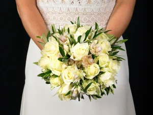 Een close up foto van een bruidsboeket met witte roze en zachtroze bloemen.