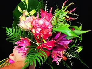 Een boeket bloemen met hele mooie, felle kleuren bloemen zoals roze, rood, geel en groen.