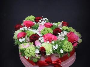 Flowerbox Liefdes hart kleuren. Een box met verschillende witte, roze en zachtroze bloemen en rode rozen, gestoken in een stuk oase. Mooi voor de liefde of bijvoorbeeld Valentijnsdag.