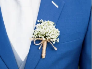 Een corsage met een witte bloem, afgewerkt met een touwtje.
